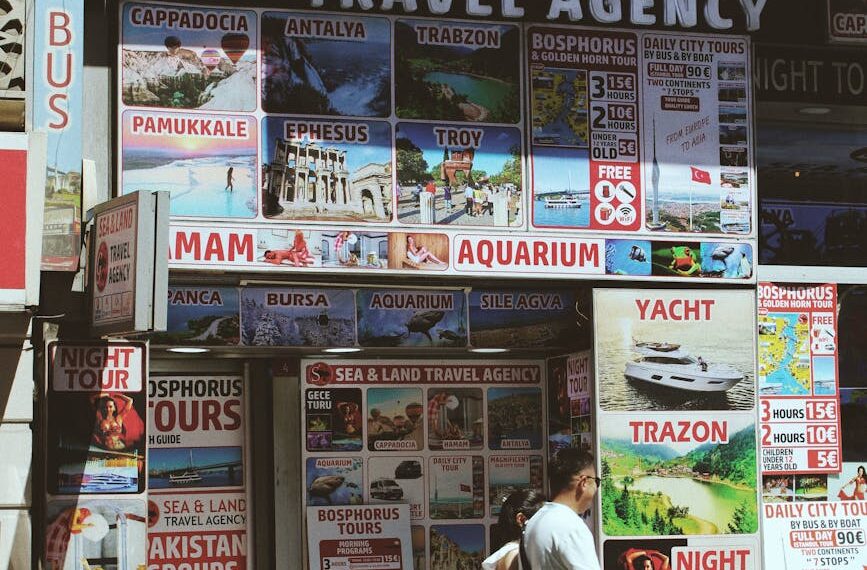 a man walking down a street with a travel agency sign