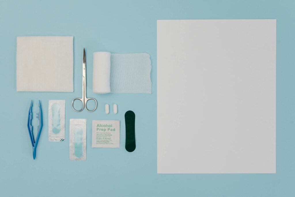 Organized display of medical tools and supplies including gauze, scissors, and bandages on a blue surface.