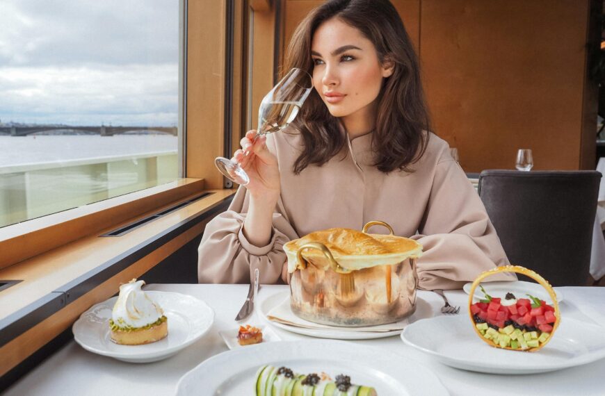 Elegant woman savoring wine during a gourmet meal on a luxury cruise, with sea views.