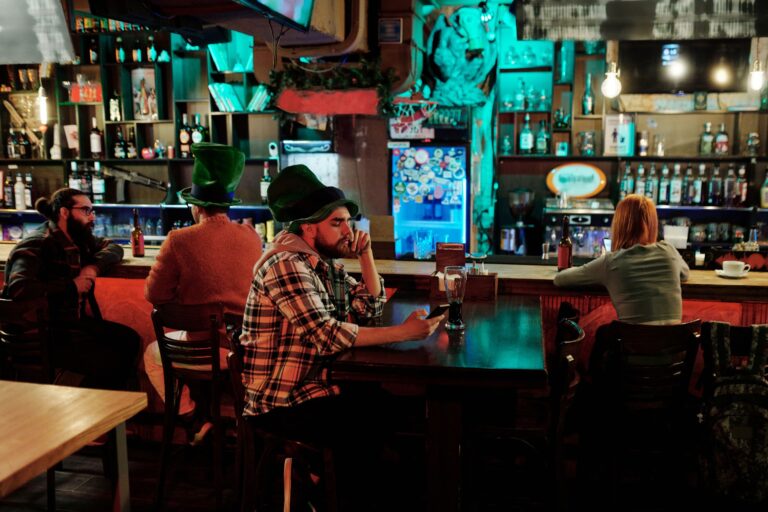Group of friends enjoying St. Patrick's Day at a cozy pub with vibrant decor.