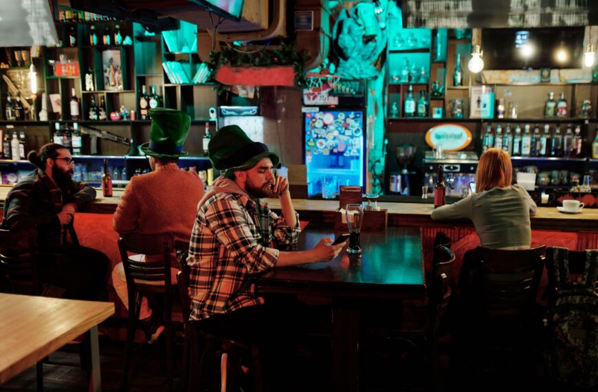 Group of friends enjoying St. Patrick's Day at a cozy pub with vibrant decor.