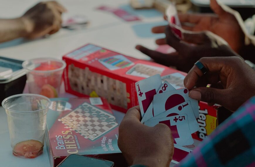 Adults enjoying card games together outdoors, creating a vibrant social atmosphere.