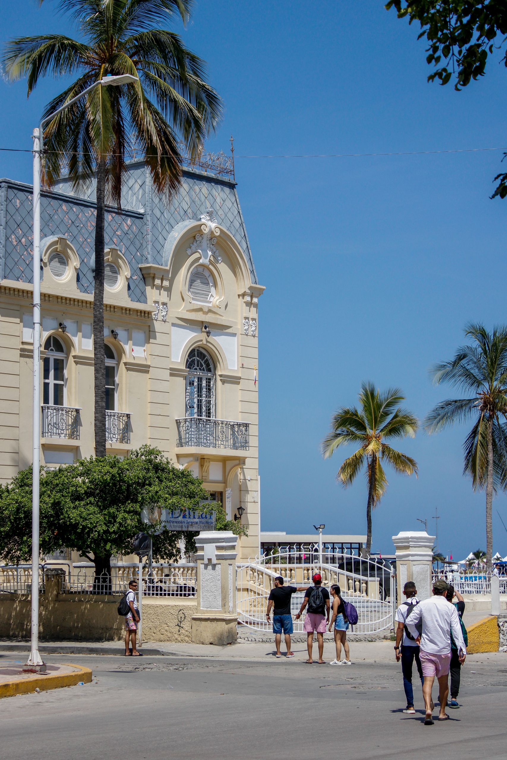 Colonial building in Santa Marta, Colombia with palm trees lining the street.