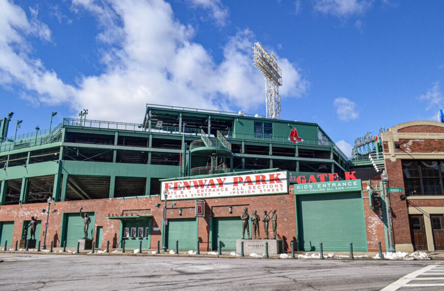 Iconic Fenway Park entrance on a clear day in Boston, showcasing historic architecture and vibrant atmosphere.