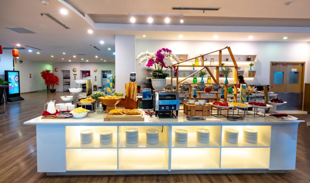 Luxurious indoor buffet table with diverse dishes and elegant decor in a brightly lit room.